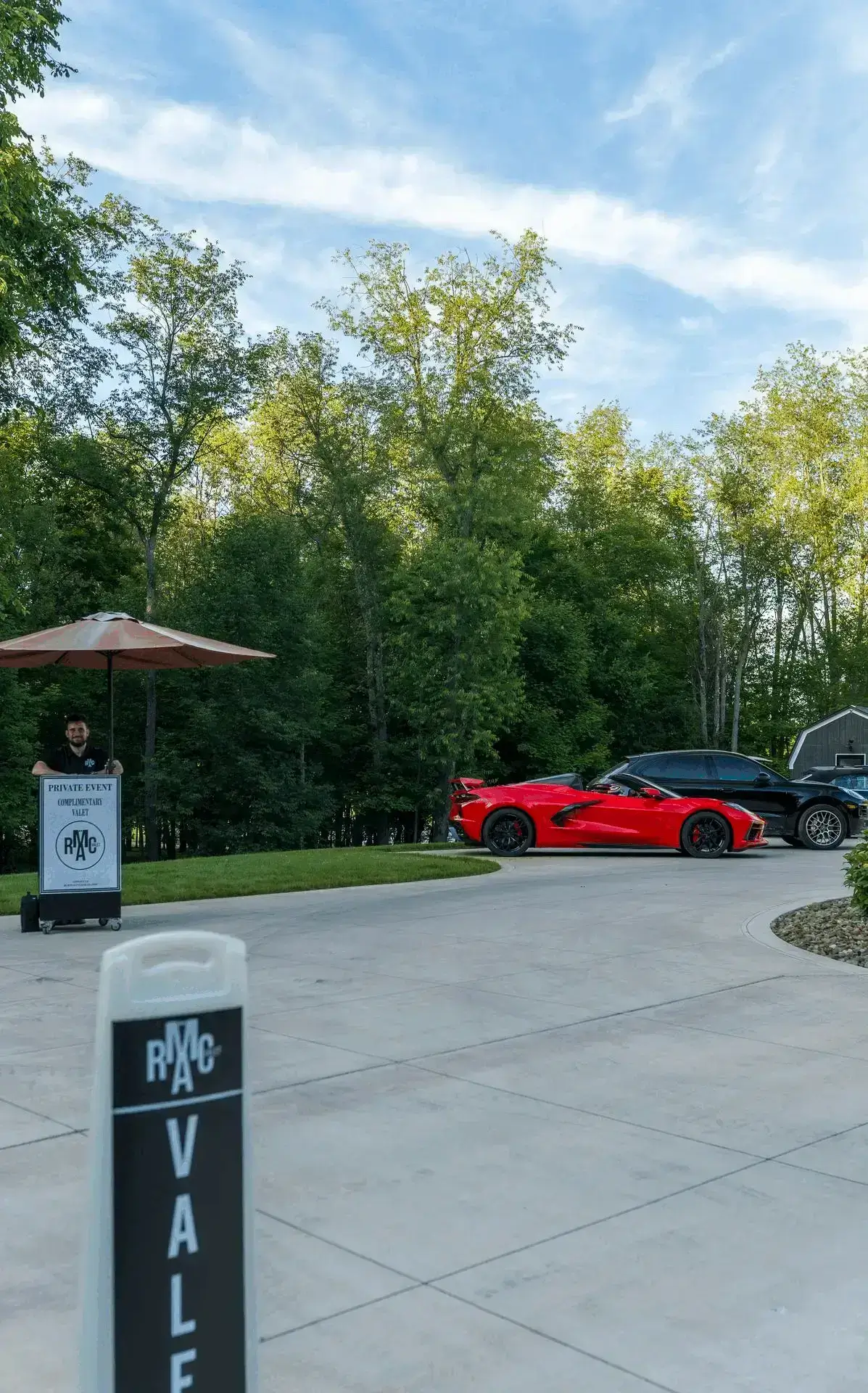 RCMA Valet booth with umbrella and red Corvette at a private residence