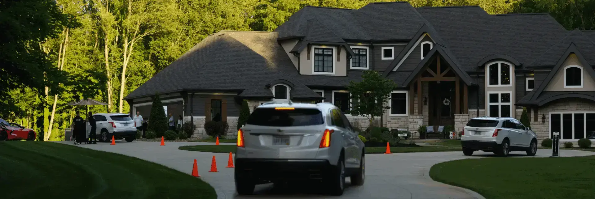 Panorama of driveway with RCMA Valet booth, cones, and attendants at sunset