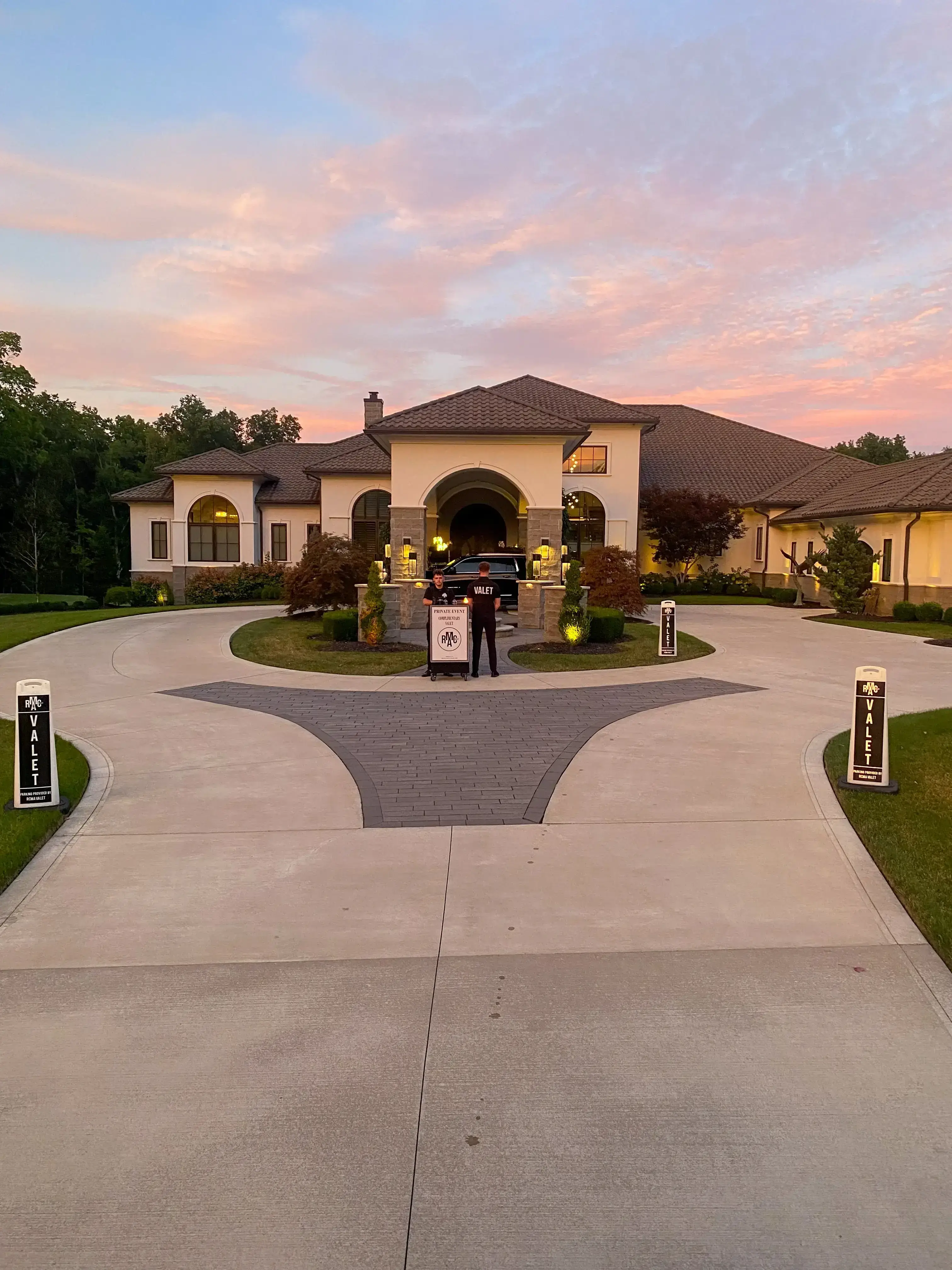 Vehicles circulating a roundabout driveway with RCMA Valet attendants